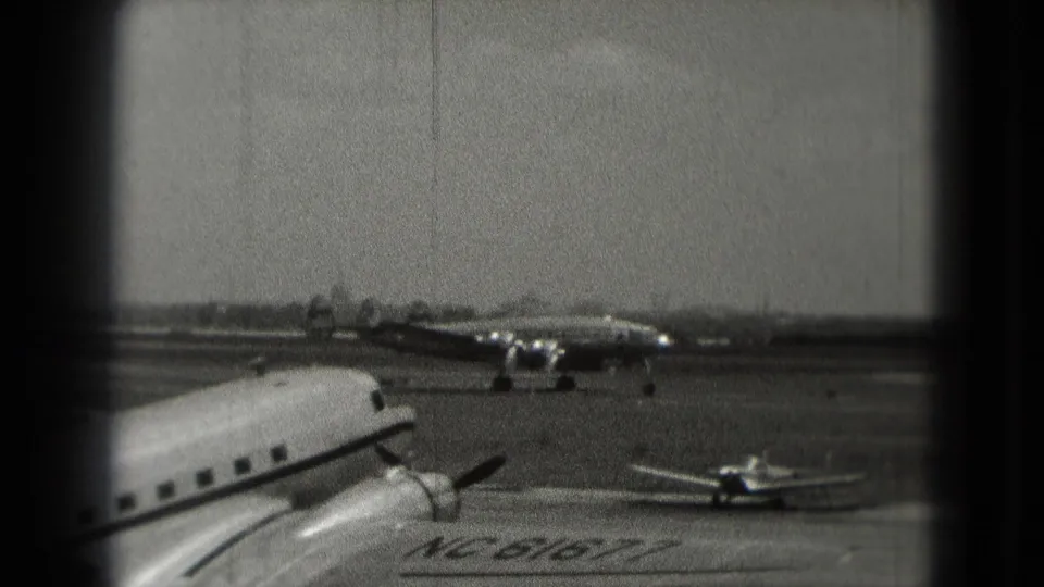 The final frame shows a 1975 Washington, DC airport tarmac scene with a foreground propeller aircraft and distant aircraft under hazy exposure.