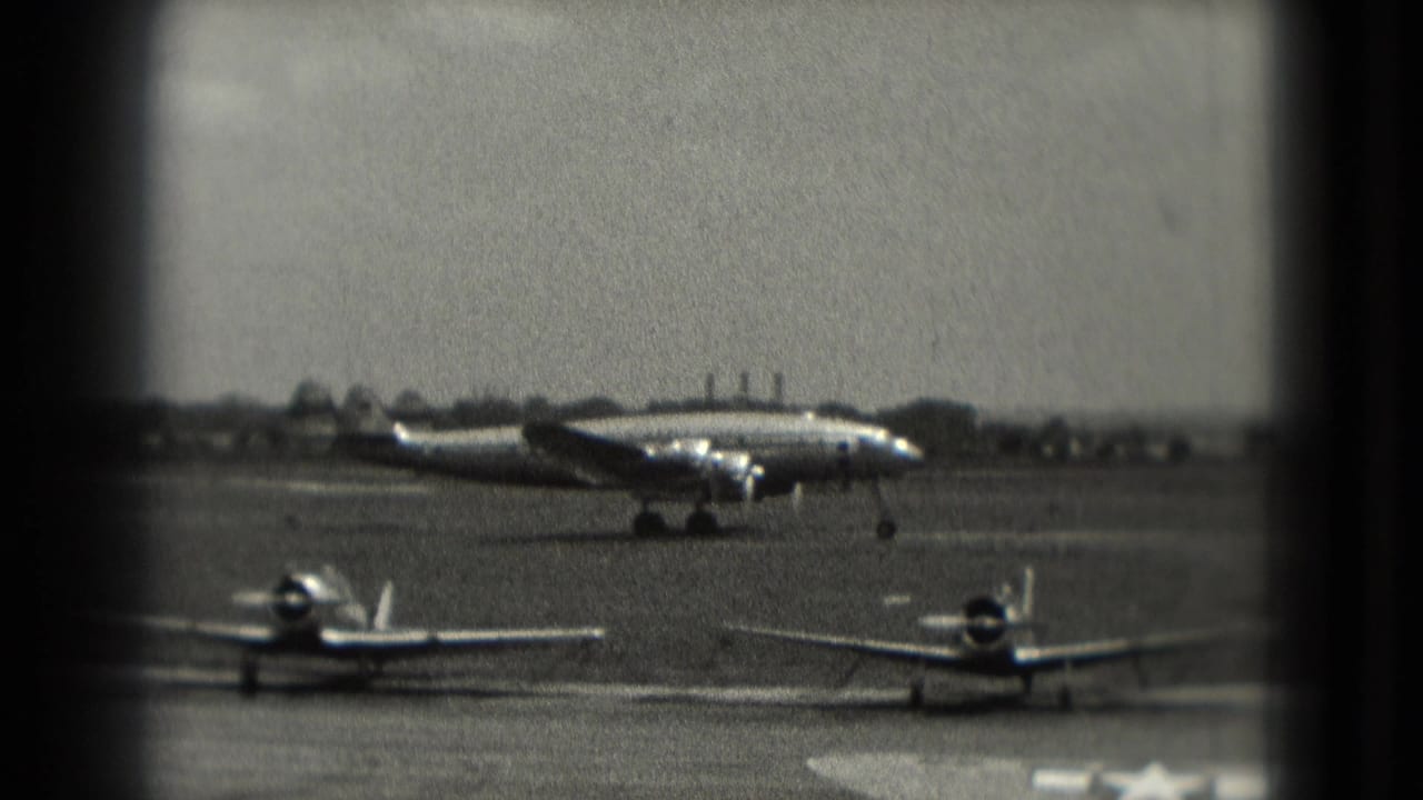 Propeller aircraft taxiing on the runway with two smaller planes in front.