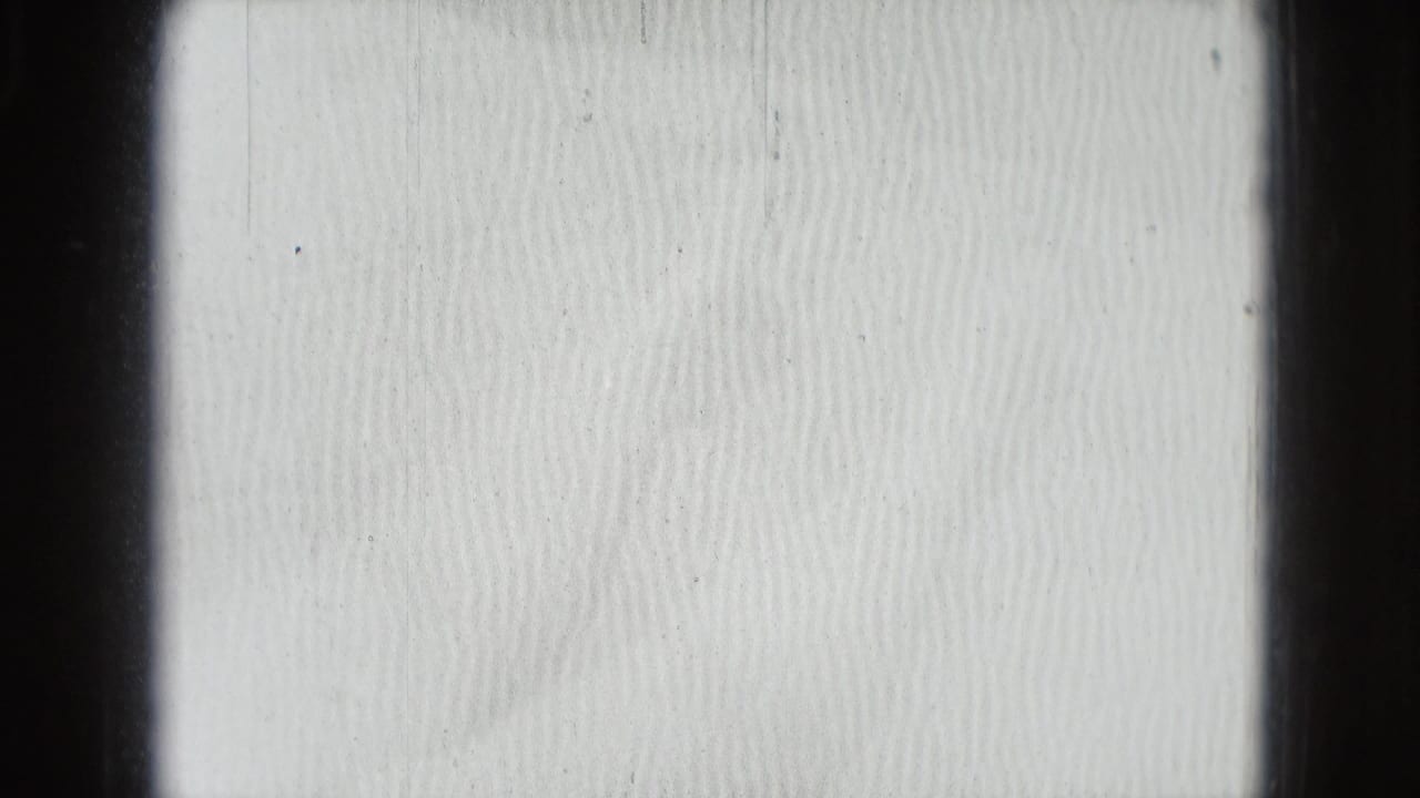 Overexposed opening frame from a 1975 Washington DC 8mm home movie, mostly bright texture with dark film-frame borders.