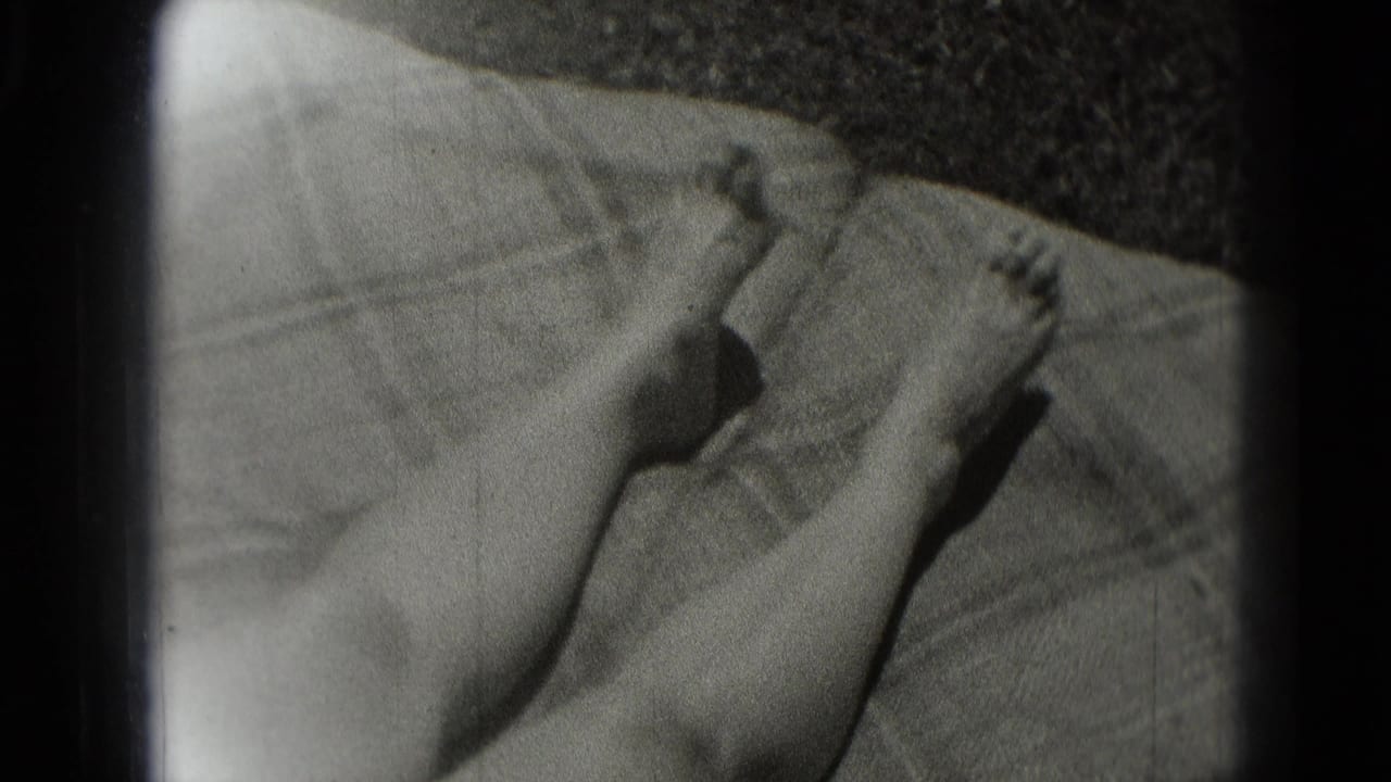 Bare feet and lower legs rest on a blanket in this 1975 Washington DC home-movie frame, with soft focus and visible film grain.