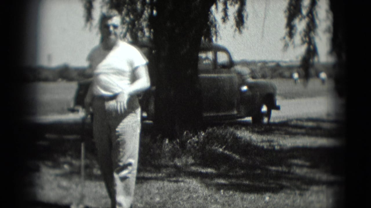 In Washington, DC 1975 home-movie footage, a man stands on a grassy recreation area with a golf club and older cars in the background.