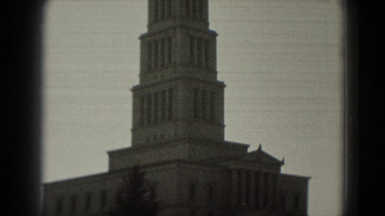 1975 Washington, DC frame with a prominent tower, stone facade, tree shapes, and visible film gate edges.
