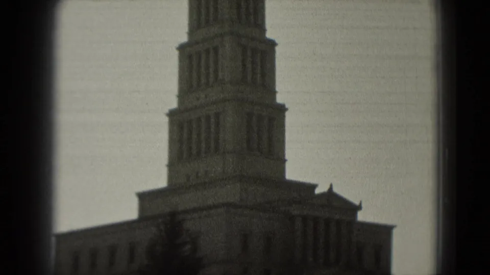 1975 Washington, DC frame with a prominent tower, stone facade, tree shapes, and visible film gate edges.