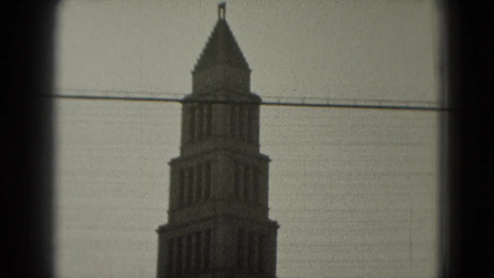 1975 Washington, DC home-movie still showing the tower top, pointed roof, small flag, and overhead wire.