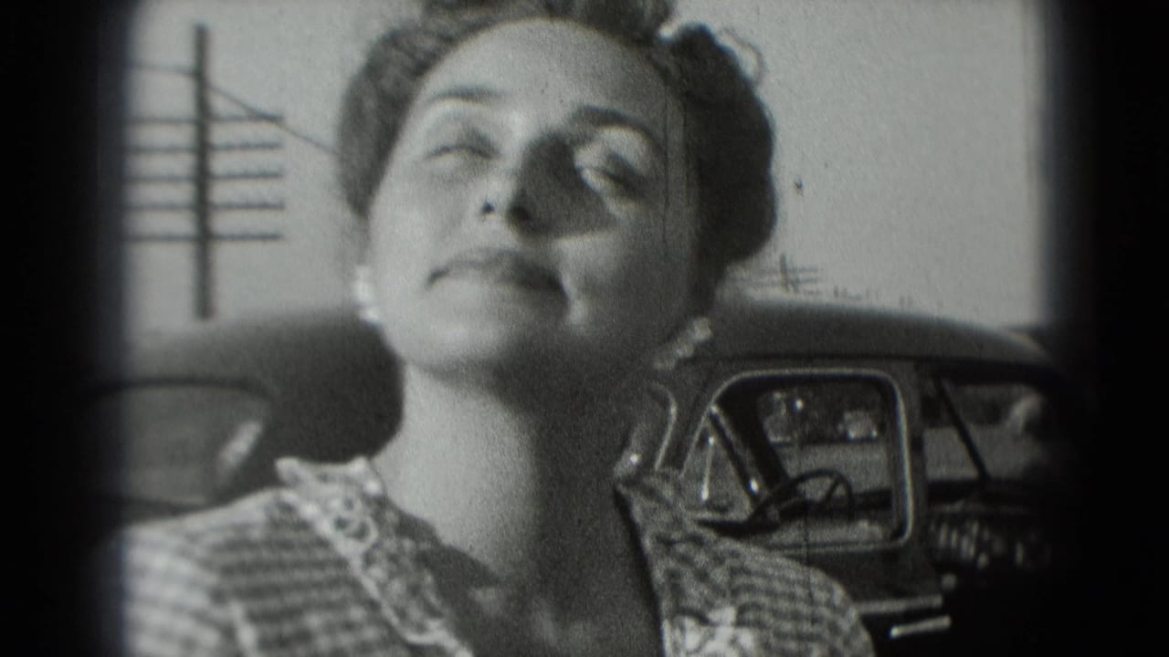 In 1975 Washington DC footage, a woman in a checkered dress tilts her face upward near a parked car.