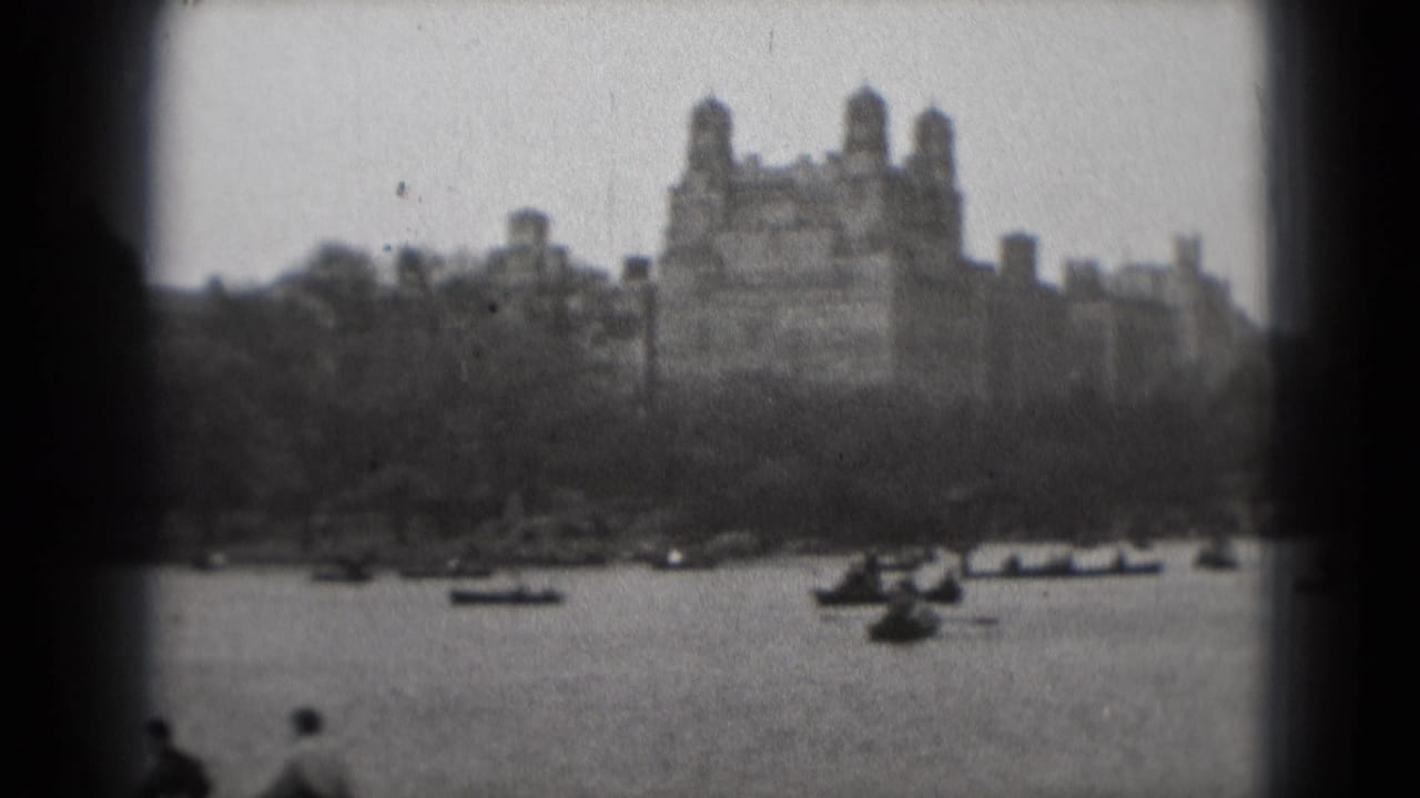 1975 Washington, DC home-movie view of rowboats on water with a large distant building beyond trees.