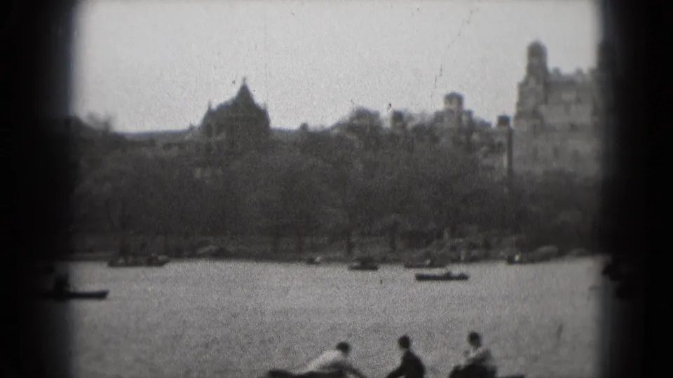 1975 Washington, DC park footage showing rowboats on a lake with visitors seated along the lower edge of the frame.
