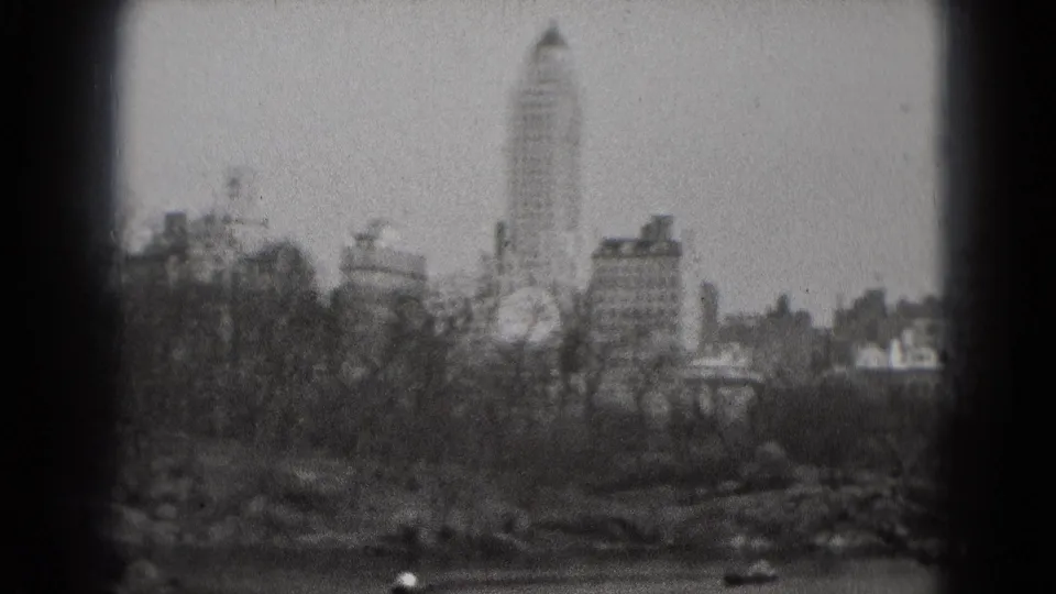 Washington, DC park panorama showing a lake, rowboats, leafless trees, and distant high-rise buildings in 1975 home-movie footage.