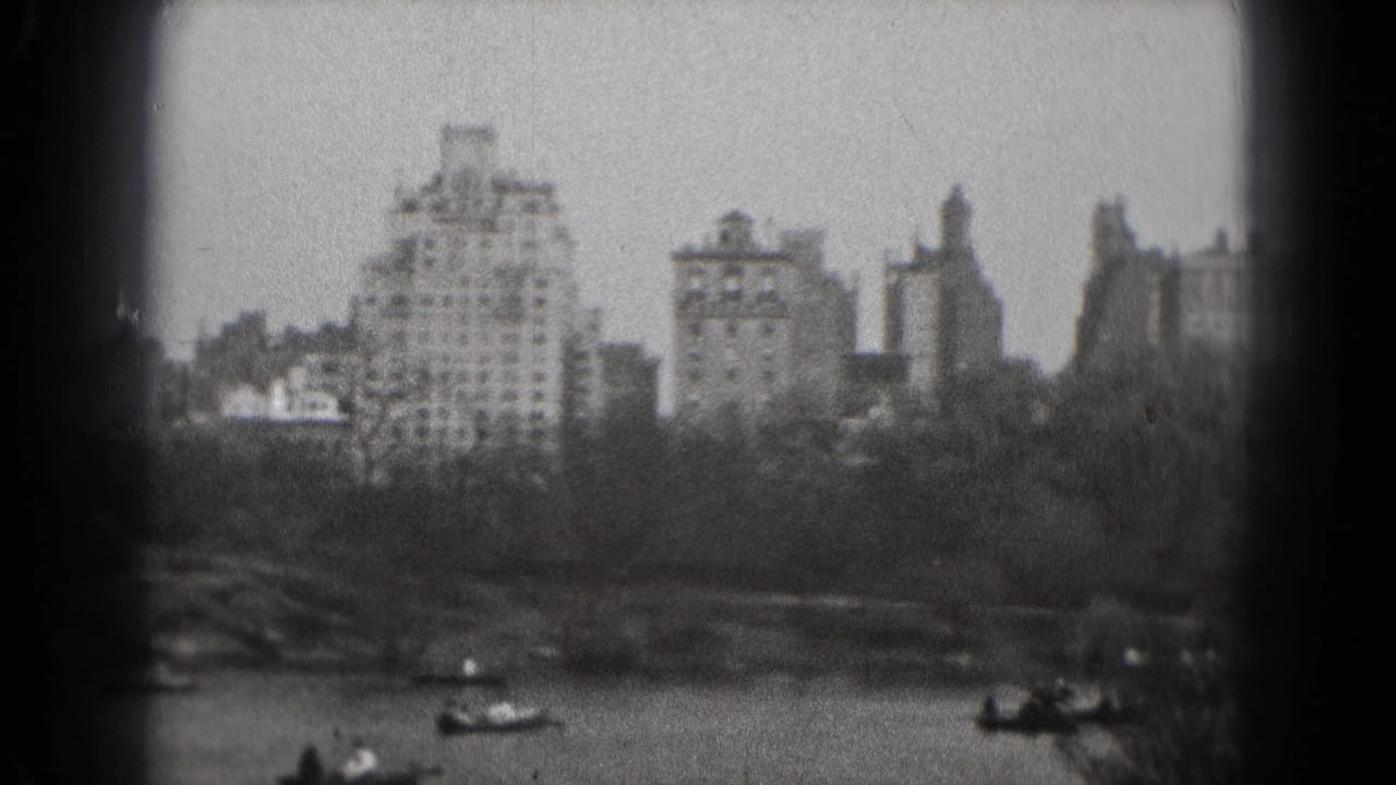 1975 Washington, DC home-movie frame showing a soft-focus skyline across a lake with small boats near the shore.