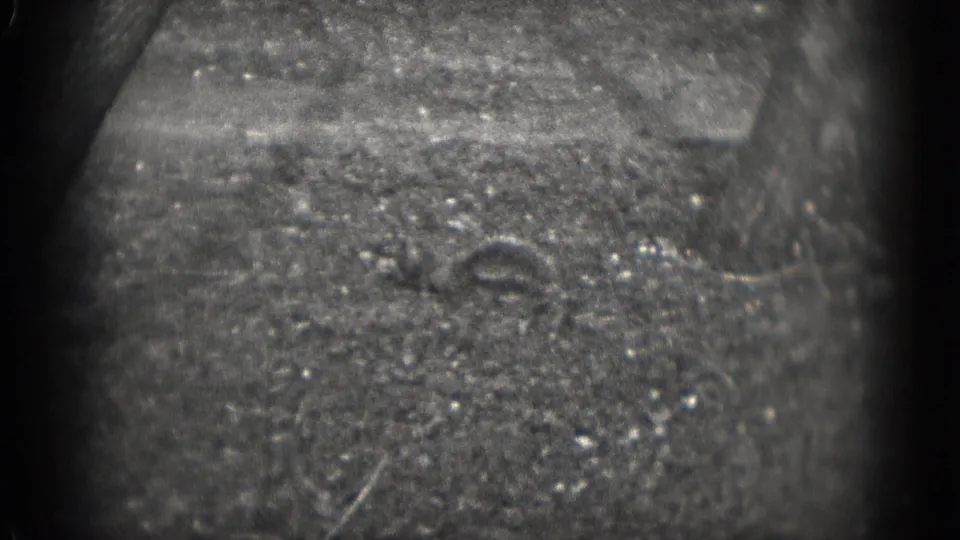 Soft black-and-white 8mm view of rough outdoor ground, likely part of the same 1975 Washington DC home-movie sequence.