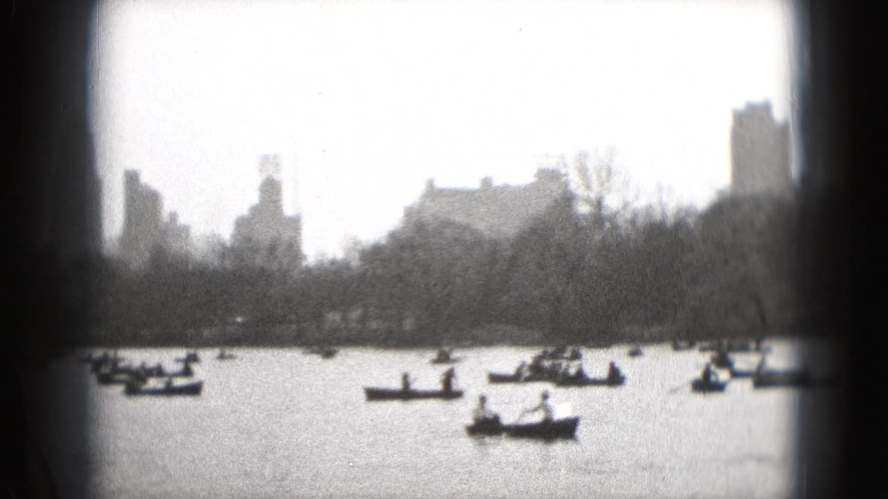 Small boats on water with a distant skyline and bare trees behind them.