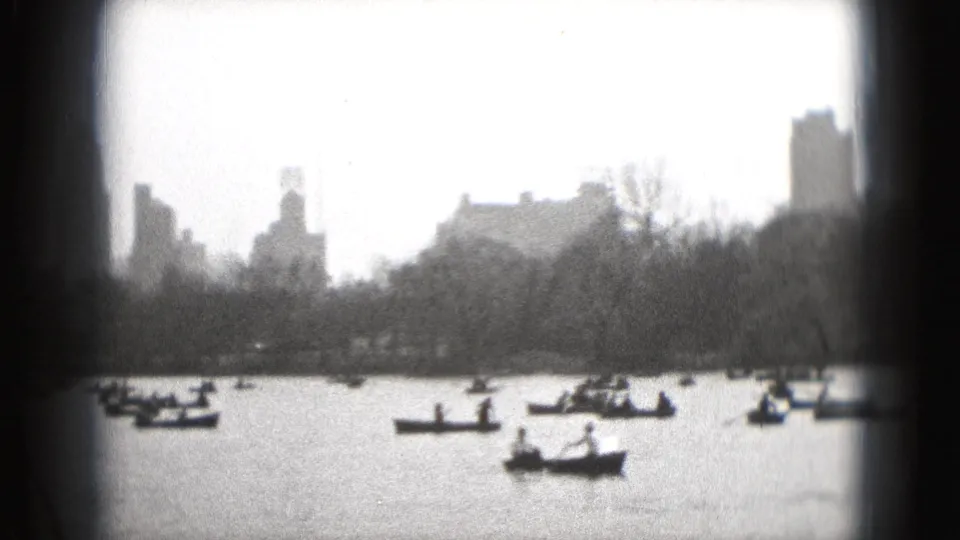 1975 8mm frame, location metadata identifies Washington DC, showing small boats on water below a hazy city skyline.