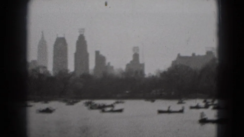 Soft 8mm view of small boats on water with a hazy urban skyline in the distance, identified by metadata as Washington DC.