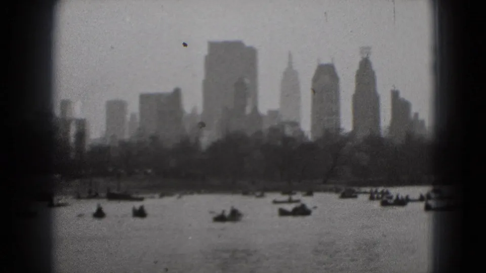 1975 8mm Washington DC view of small boats on water with a distant skyline softened by haze and film grain.