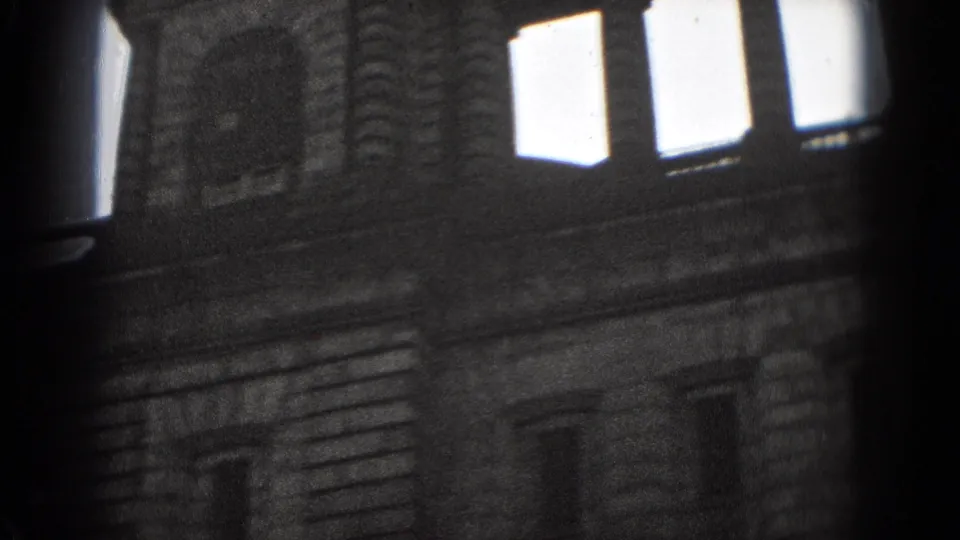 1975 Washington, DC 8mm detail of a historic-looking facade with arched trim, bright windows, and heavy film grain.