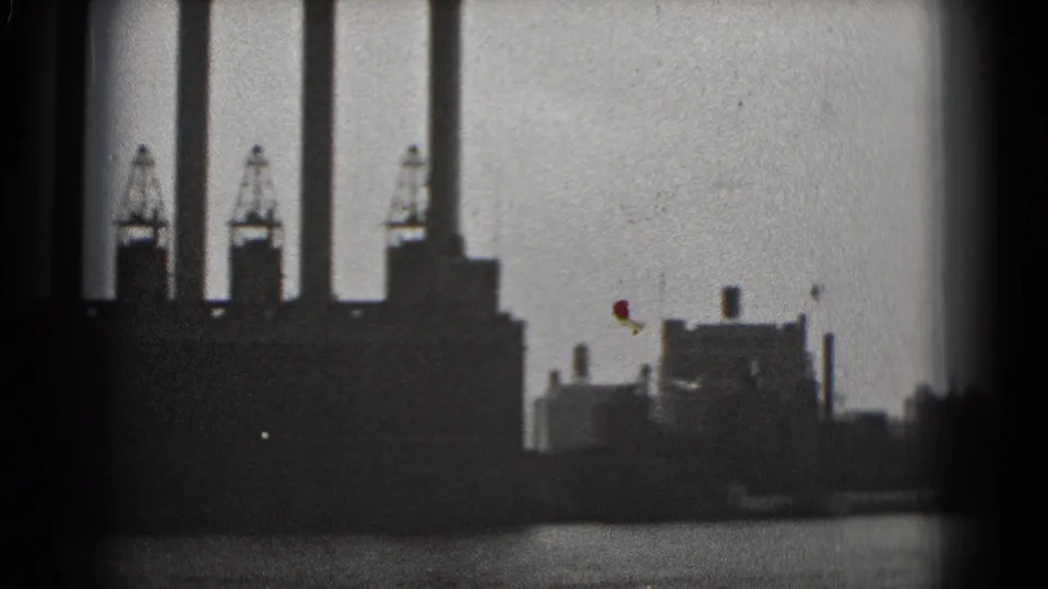 Black-and-white 1975 Washington DC 8mm frame showing silhouetted smokestacks, cranes, and industrial buildings beside water.