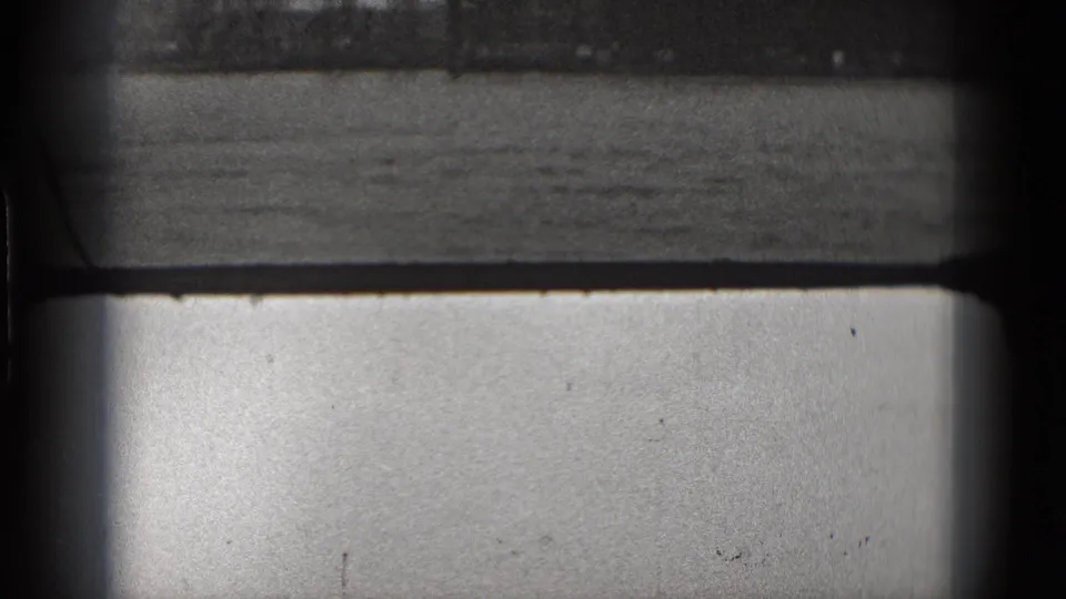 Washington DC archival 8mm view of water and a distant industrial horizon, heavily framed by dark vertical and horizontal shapes.