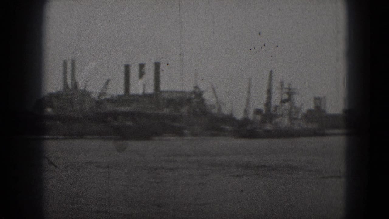 Washington, DC waterfront view from 1975 metadata, showing industrial buildings and smokestacks across water within a soft 8mm frame.