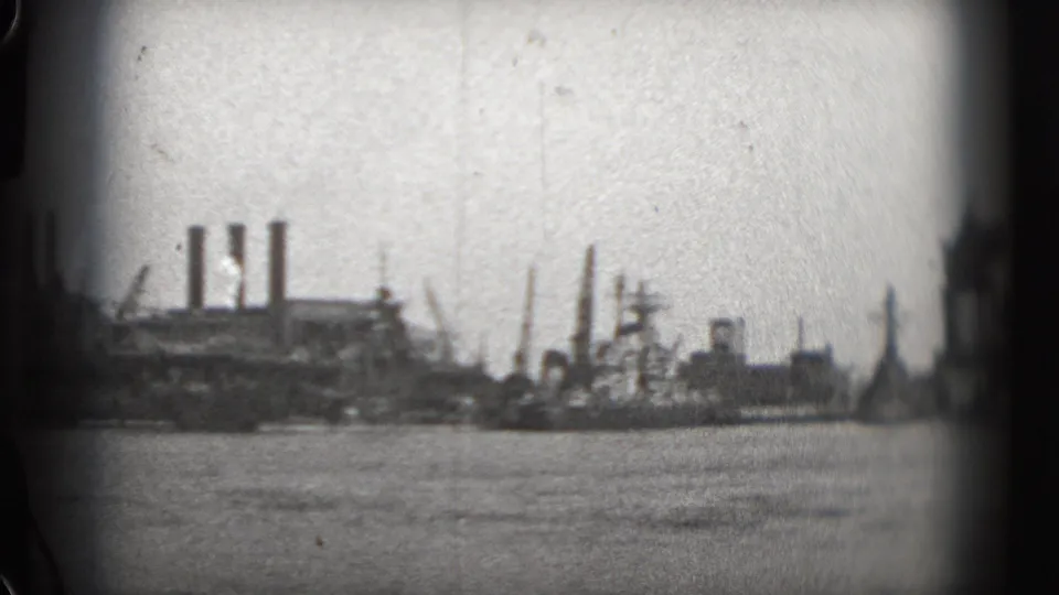 1975 Washington, DC waterfront view with soft-focus industrial buildings, smokestacks, and river water in the foreground.