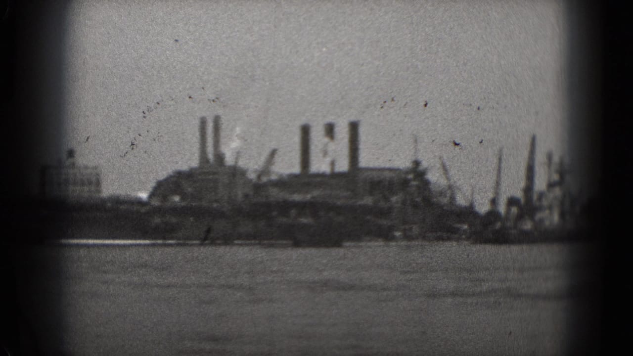 Distant Washington, DC waterfront industry appears across the water, with smokestacks and soft 8mm focus.