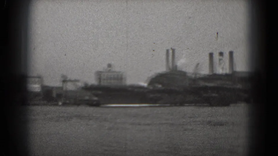 A 1975 Washington, DC river view shows industrial structures, smokestacks, and a small vessel or barge near shore.