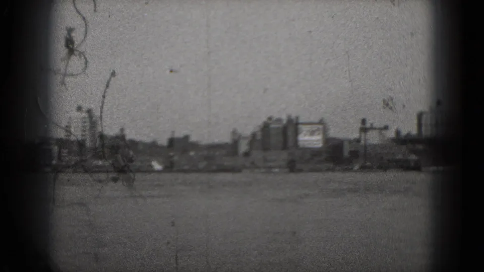 1975 8mm Washington, DC river view with distant urban buildings and heavy film grain.