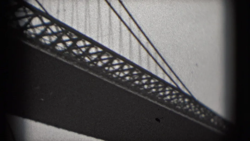 1975 8mm view from the Washington DC waterfront showing the underside of a bridge with lattice truss and suspension cables.