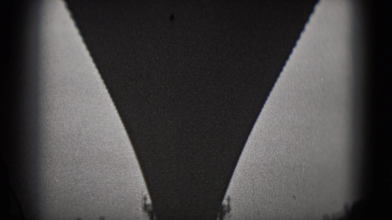 Close, high-contrast 8mm view under a large bridge structure in Washington, DC, with pale side openings and heavy shadow.