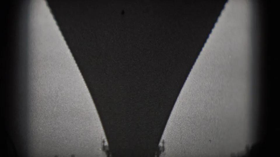 Close, high-contrast 8mm view under a large bridge structure in Washington, DC, with pale side openings and heavy shadow.