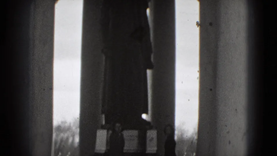 A shadowed statue and classical columns frame a silhouetted visitor in this 1975 Washington, DC monument view.