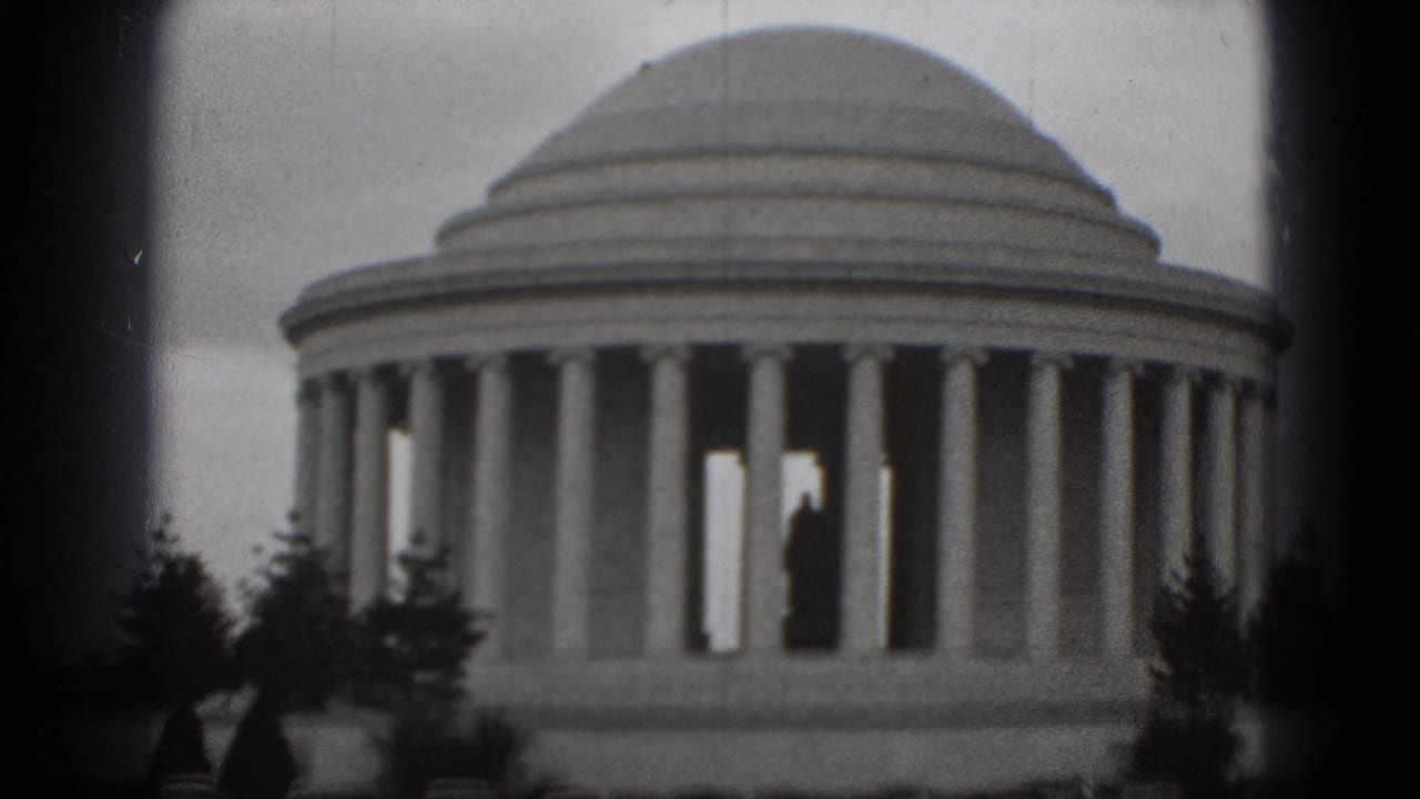1975 Washington, DC 8mm frame showing the Jefferson Memorial columns and dome, with a distant visitor silhouette visible inside the structure.