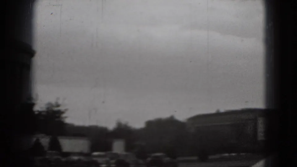 Distant Washington, DC view from the same 1975 8mm clip, with trees, low buildings, cars, and heavy viewfinder borders.