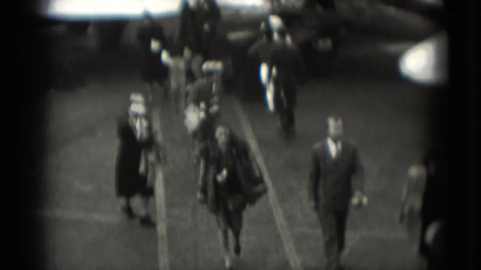 In Washington, DC 1975 home-movie footage, well-dressed travelers walk across a tarmac after leaving an aircraft.