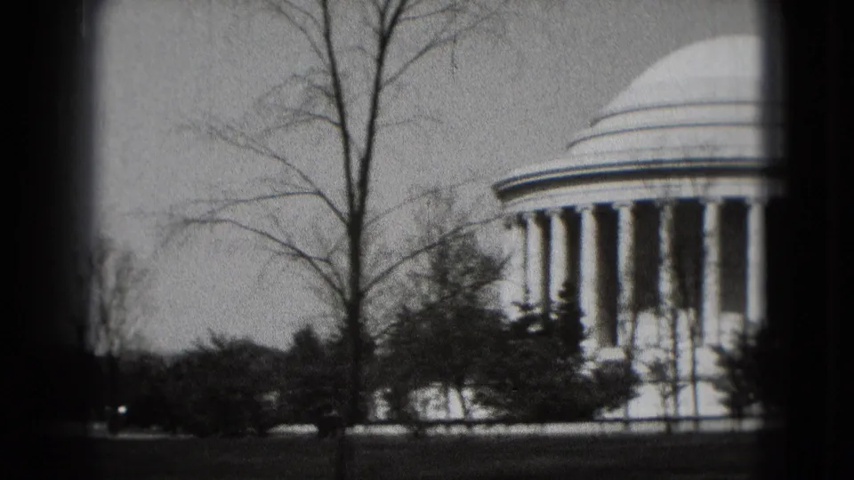 1975 8mm view of the Jefferson Memorial in Washington, DC, with its dome and columns partially obscured by bare trees.