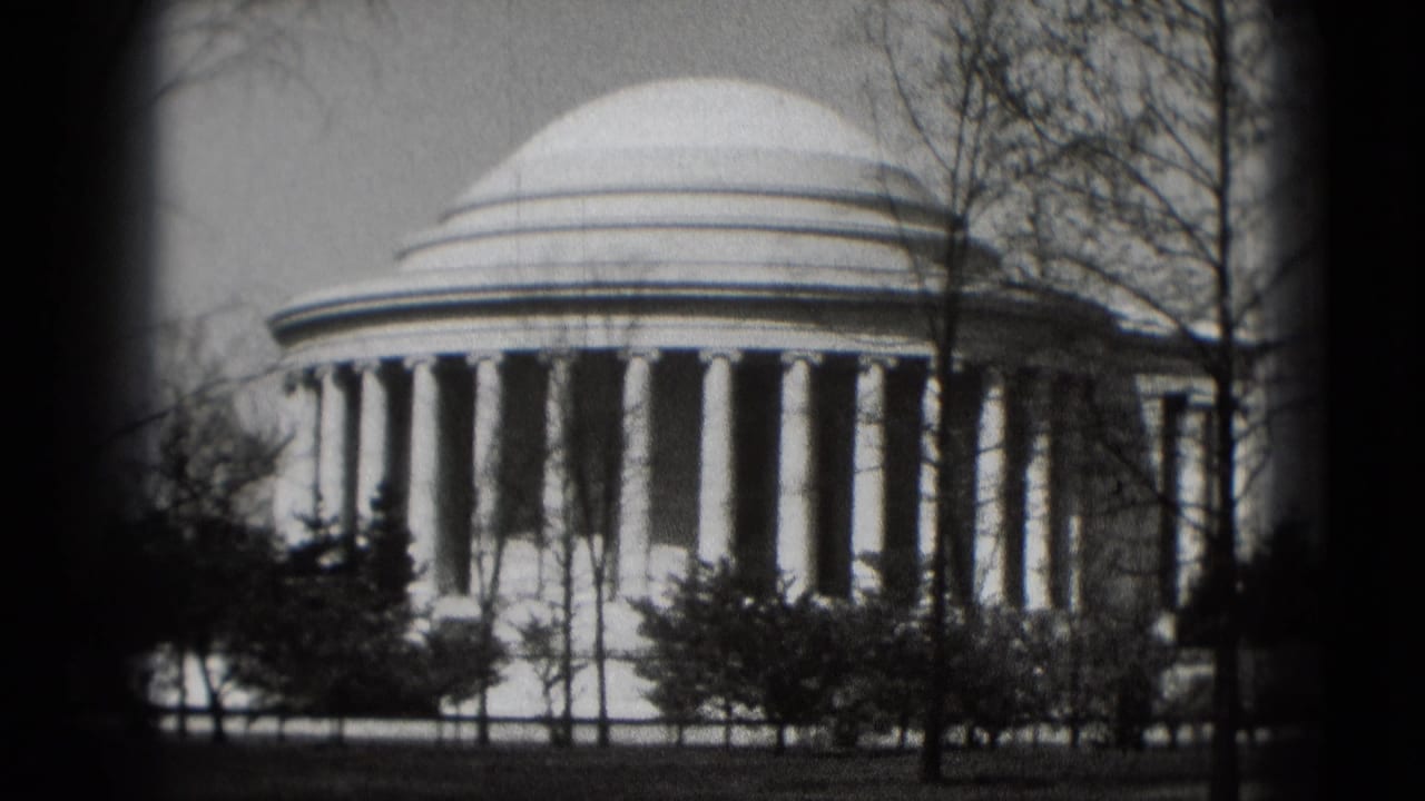 Jefferson Memorial dome and columns framed by bare trees and dark film edges.