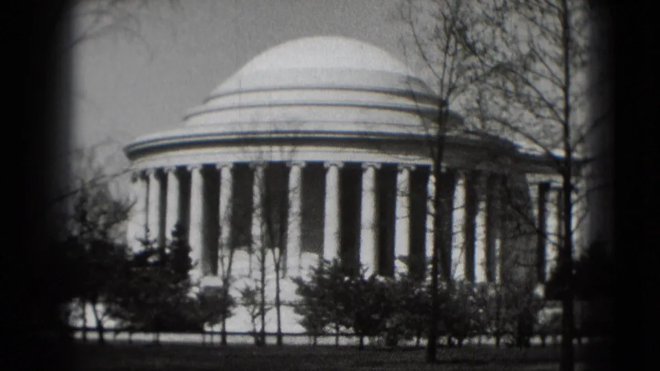 1975 8mm view of the Jefferson Memorial in Washington, DC, with its dome and columns partly framed by leafless trees.