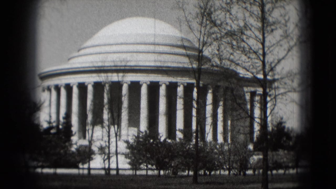 Jefferson Memorial seen from the grounds with dome, columns, trees, and shrubs.
