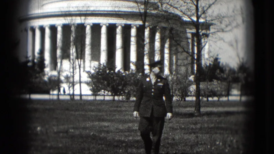 The uniformed man walks near the frame edge as the Lincoln Memorial columns fill the background in 1975 Washington DC footage.