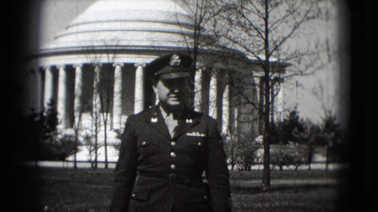 In 1975 Washington, DC, a uniformed adult man poses in front of the Jefferson Memorial dome and columns on black-and-white 8mm film.