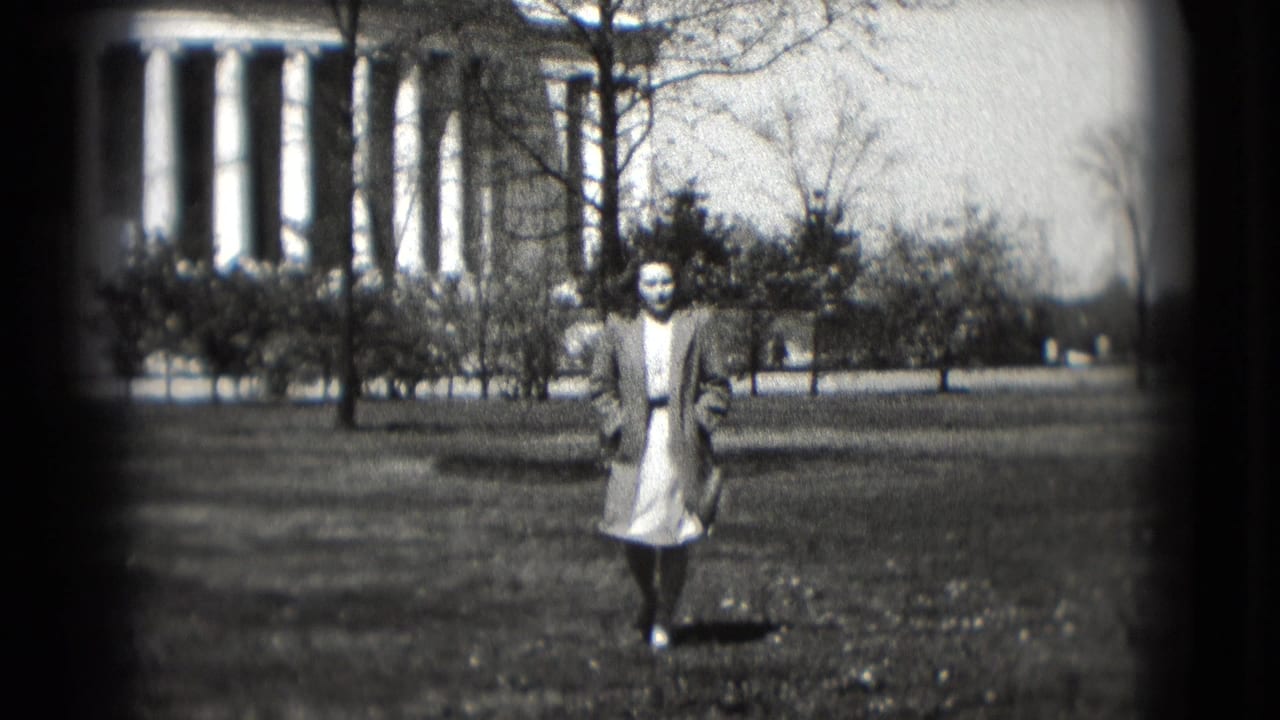 A woman walks toward the camera on grass in front of the Jefferson Memorial, framed by bare trees and soft 8mm exposure.