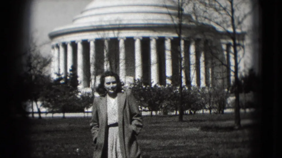 1975 Washington, DC home-movie still of a woman standing or walking near center frame before a white domed landmark.