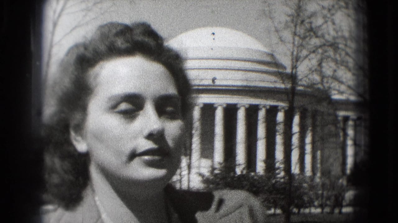 A young woman is filmed from a slightly different angle in Washington, DC, with the Jefferson Memorial dome and columns behind her.