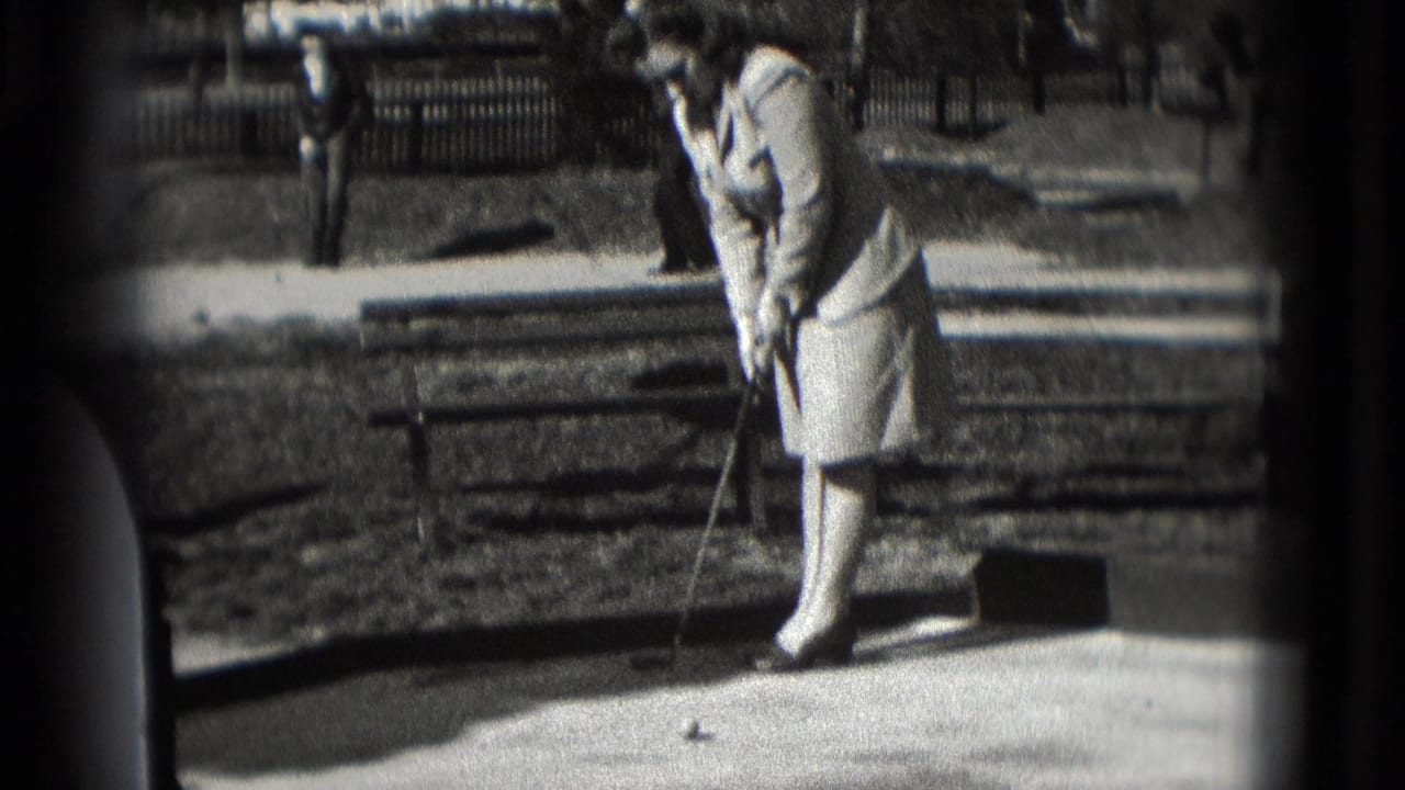 In supported 1975 Washington, DC home-movie footage, a woman in a light dress prepares a mini-golf putt on a sunny outdoor course.