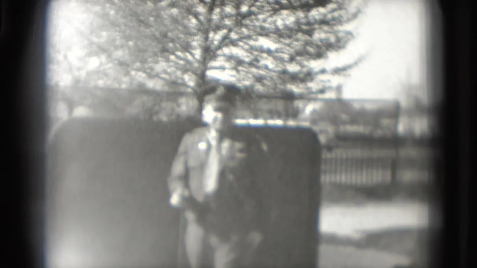 A uniformed man faces the camera near the mini-golf course in 1975 Washington, DC, partially softened by exposure and dark frame edges.