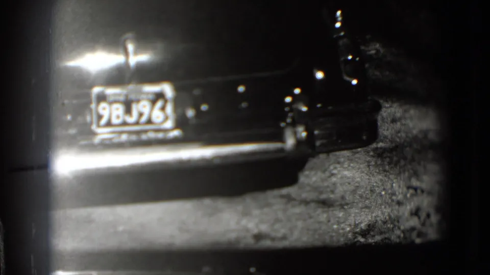 Later frame showing the rear license plate 9BJ96, chrome bumper and roadside ground in 1975 Washington, DC home-movie footage.