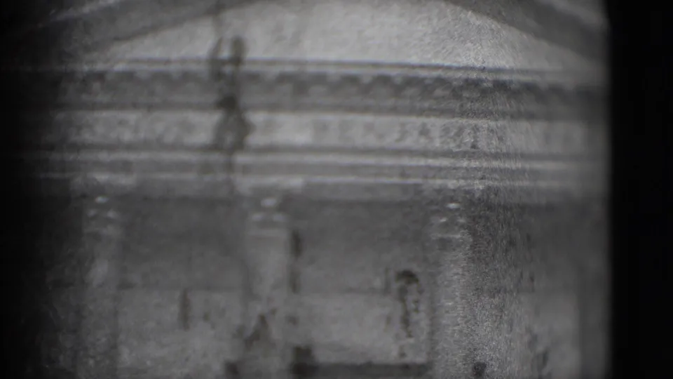 Grainy 1975 Washington DC frame with classical stone architecture, column forms, and horizontal facade lines in soft focus.