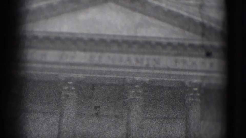 Late frame from 1975 Washington DC 8mm footage showing a pediment, columns, and faint engraved lettering across a historic stone facade.
