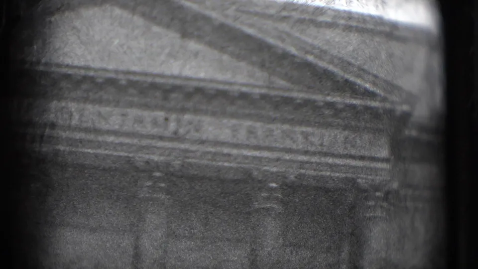1975 8mm Washington, DC frame showing a soft, grainy close view of a classical public building facade and columned portico.