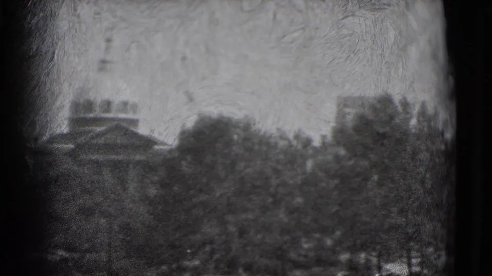 1975 Washington, DC home-movie frame showing tree canopies and distant urban buildings through soft 8mm focus.