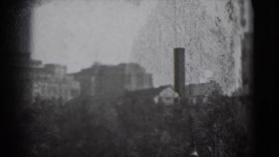 1975 Washington, DC frame with blurred urban buildings, trees, a vertical chimney, dust marks, and strong 8mm texture.